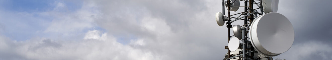 Telecommunications towers against cloudy sky